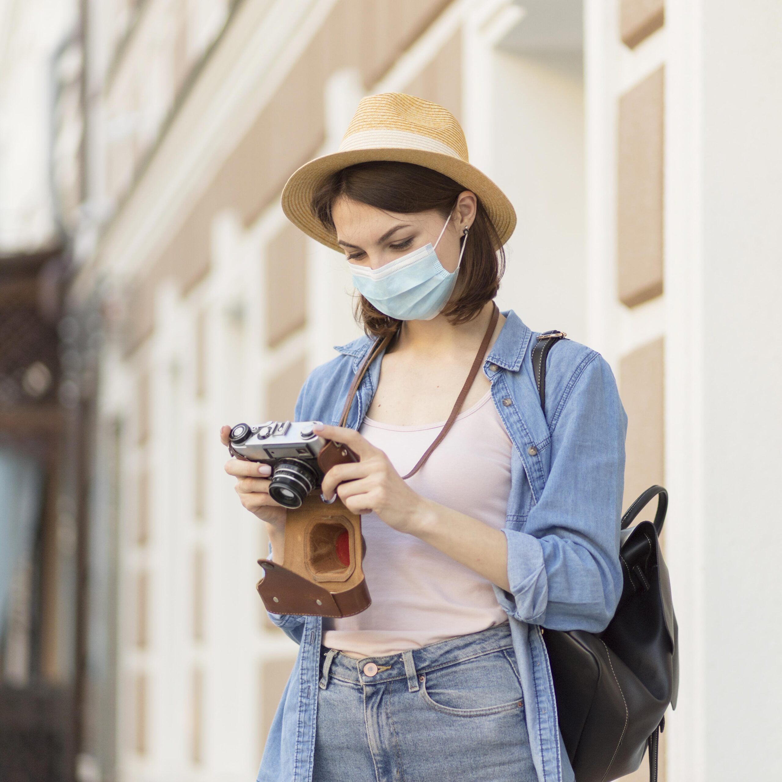 traveller-with-hat-medical-mask-checking-pictures